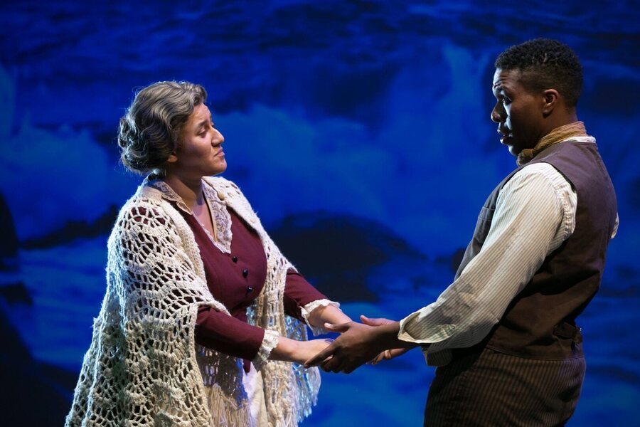 Gabriel Walker as Bartley, taking his mother's hands before the sea projection.